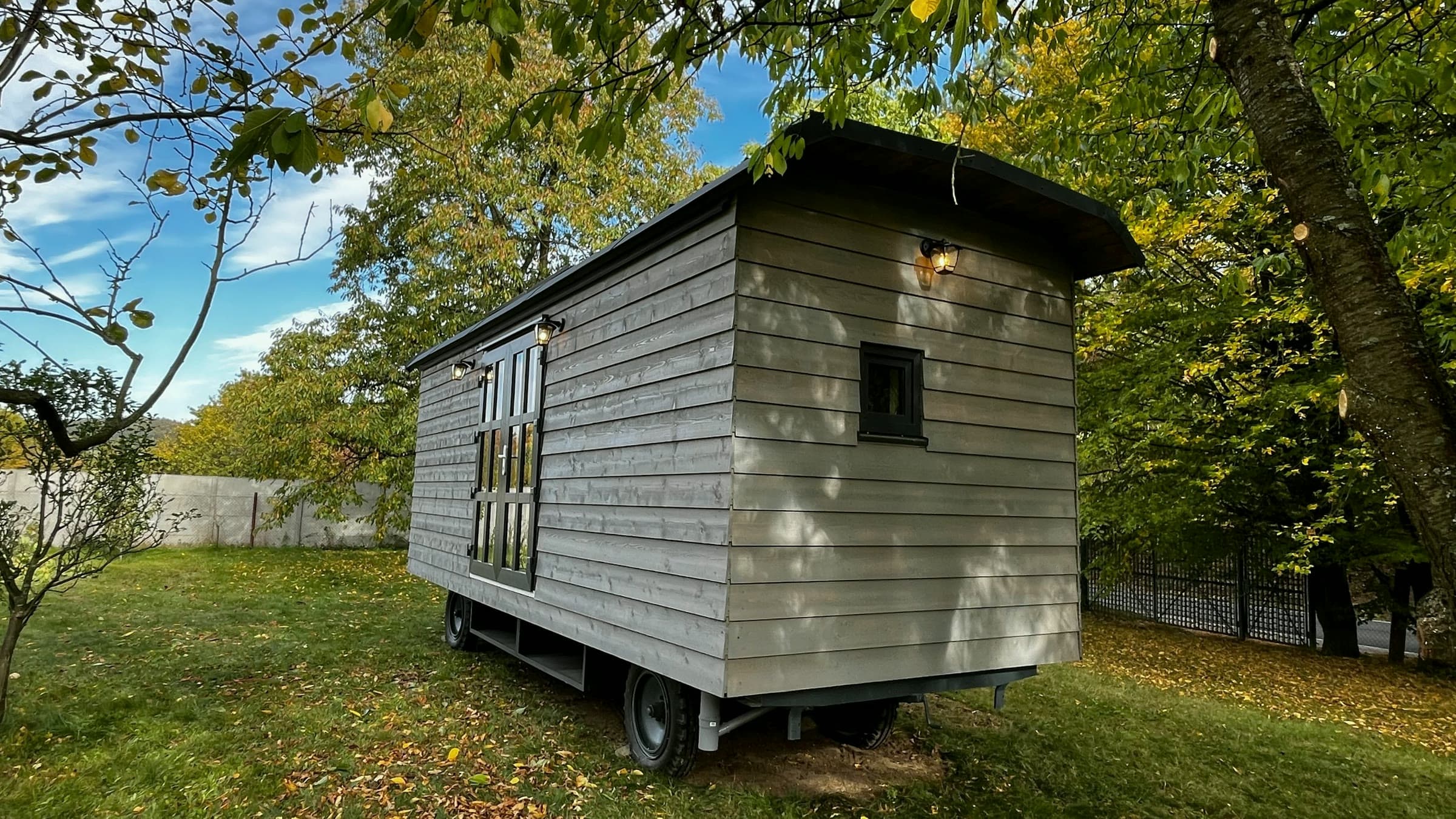 Maringotka pod korunou stromu, modré nebe